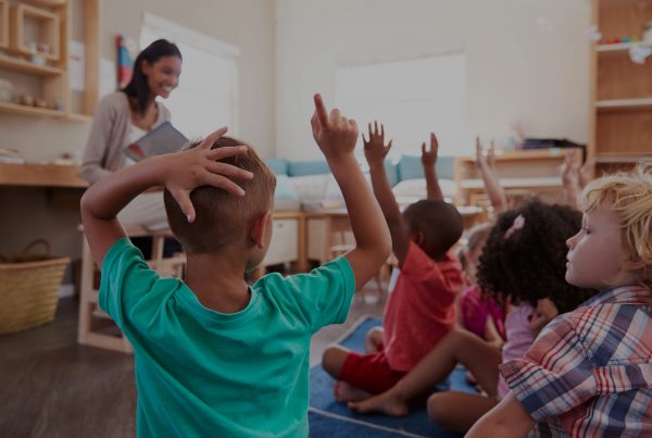 Pupils At Montessori School Raising Hands To Answer Question