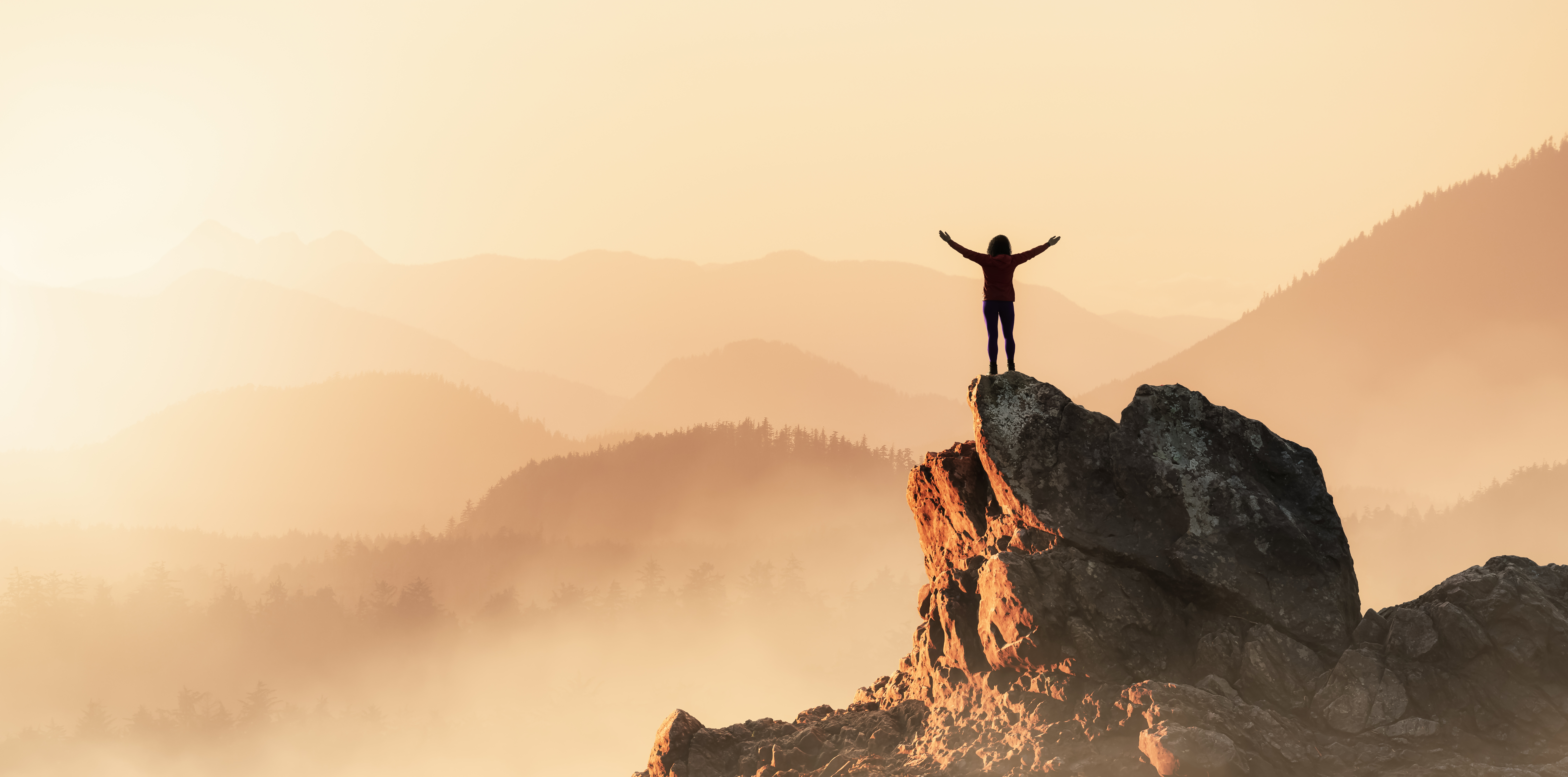 Adventurous Woman Hiking on the Rocky Coast with Mountains and Dramatic Sunset Sky.
